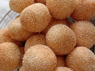 Kuih bom bijan goreng berwarna keemasan dan disaluti bijan putih