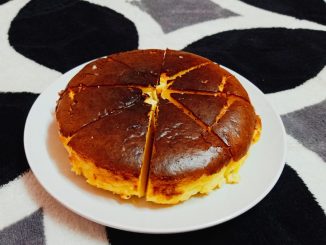 Burnt cheesecake dengan bahagian atas keperangan dan tekstur lembut berkrim di bahagian dalam, dihidangkan selepas disejukkan.