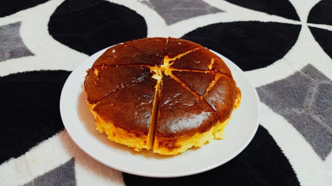 Burnt cheesecake dengan bahagian atas keperangan dan tekstur lembut berkrim di bahagian dalam, dihidangkan selepas disejukkan.