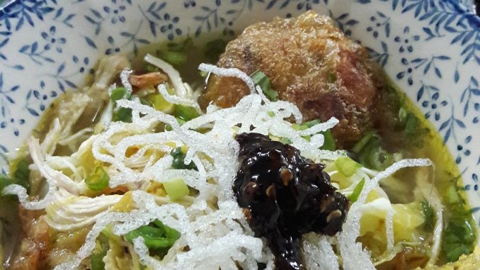 Bihun soto dihidangkan dalam mangkuk bersama ayam goreng, begedil, sambal kicap, kubis, daun sup dan bawang goreng