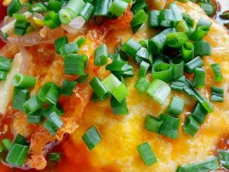 Telur bistik dengan kuah pedas manis pekat dihidangkan dalam pinggan.