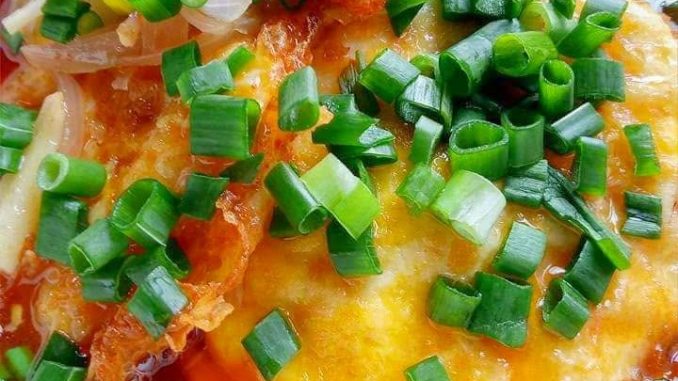 Telur bistik dengan kuah pedas manis pekat dihidangkan dalam pinggan.